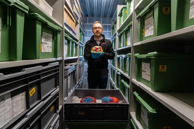 David Hanks, Collections Manager (North) for English Heritage, working in the stores checking the conditions of a collection of paper hats from Brodsworth Hall.