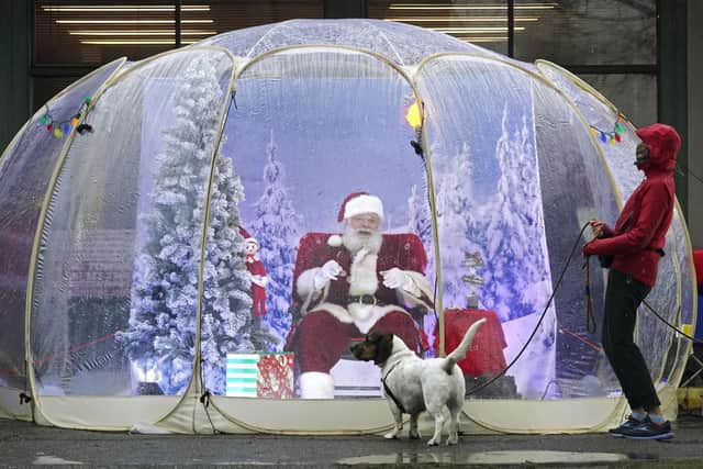 Santa inside a protective bubble in Seattle's Greenwood neighborhood. (AP Photo/Ted S. Warren)