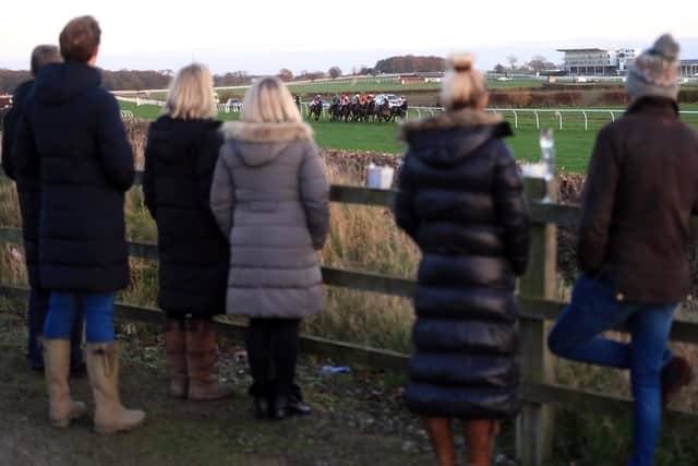 Spectators use a roadside vantage point to watch the racing at Wetherby during lockdown.