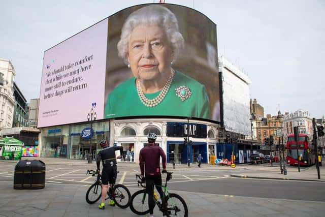 Onlookers in London watch the Queen's lockdown speech in early April.