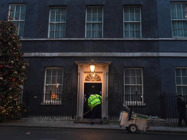 A man cleans the street in front of 10 Downing Street (photo: PA).