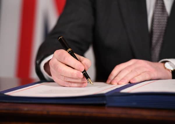 Prime Minister Boris Johnson signing the EU-UK Trade and Cooperation Agreement. Photo: Leon Neal/PA Wire