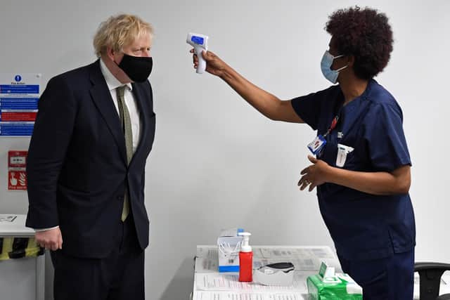 Prime Minister Boris Johnson has his temperature checked during a visit to Chase Farm Hospital in north London, on the day that the NHS ramps up its vaccination programme. Picture: Stefan Rousseau/PA Wire