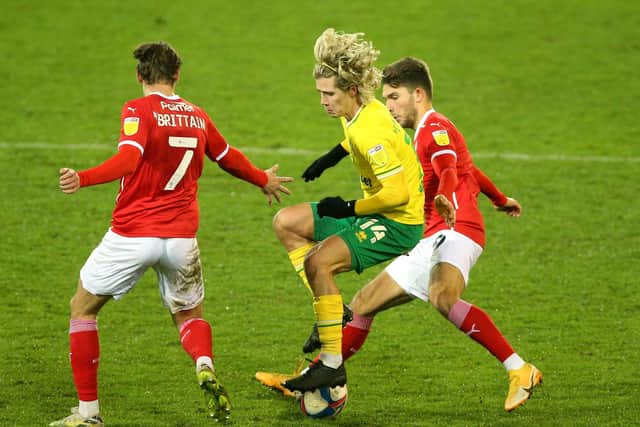 ON THE UP: Norwich City's Todd Cantwell (centre) and Barnsley's Patrick Schmidt (right) battle for the ball at Carrow Road. Picture: Nigel French/PA