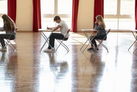 Group Of Teenage Students Sitting Examination In School Hall