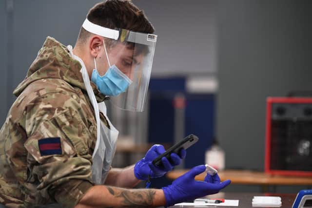 A soldier processes Covid tests at a testing centre in Liverpool last year - should the military play a role in distributing Covid vaccines?