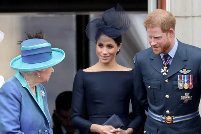 Queen Elizabeth II, Meghan, Duchess of Sussex and Prince Harry, Duke of Sussex watch the RAF flypast on the balcony of Buckingham Palace, as members of the Royal Family attend events to mark the centenary of the RAF on July 10, 2018.  (Photo by Chris Jackson/Chris Jackson/Getty Images)
