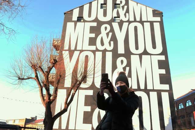 A passer-by takes a selfie in front of the mural (photo: Gary Longbottom).