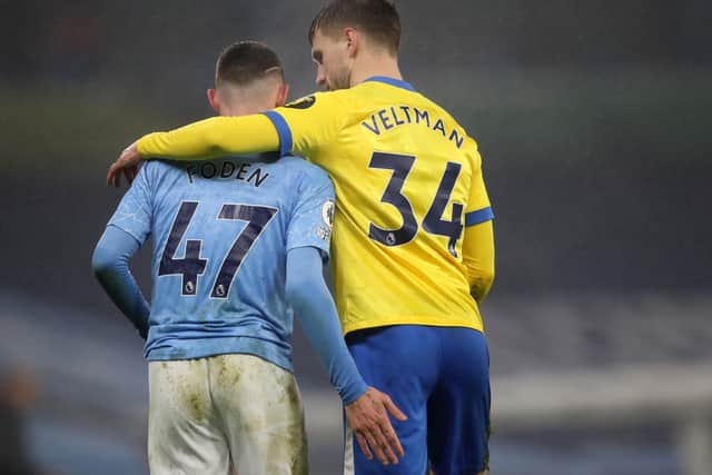 Manchester City's Phil Foden (left) and Brighton and Hove Albion's Joel Veltman embrace during the Premier League match at Etihad Stadium, Manchester.