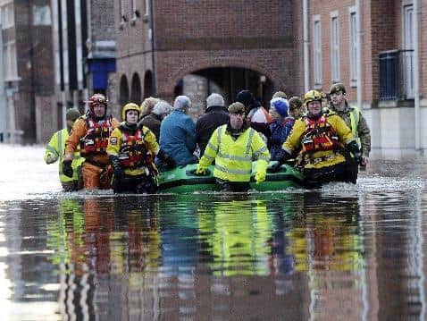 Members of the Army and rescue teams help evacuate people from flooded properties after they became trapped by rising floodwater when the River Ouse bursts its banks in York city centre. PRESS ASSOCIATION Photo. Picture date: Sunday December 27, 2015.