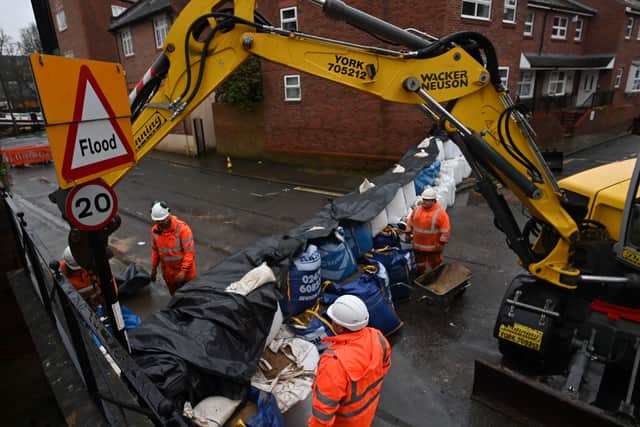 Local council employees use sandbags to prepare flood defences in a street in York, on January 19, 2021 as Storm Christoph brings heavy rains across England. (Photo by Paul ELLIS / AFP)