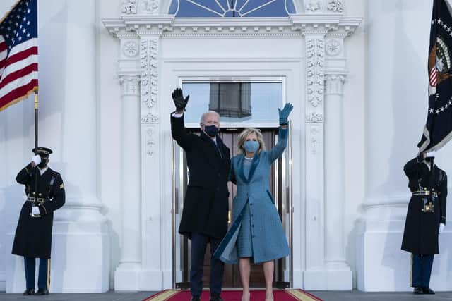 President Joe Biden and first lady Jill Biden wave as they arrive at the North Portico of the White House.