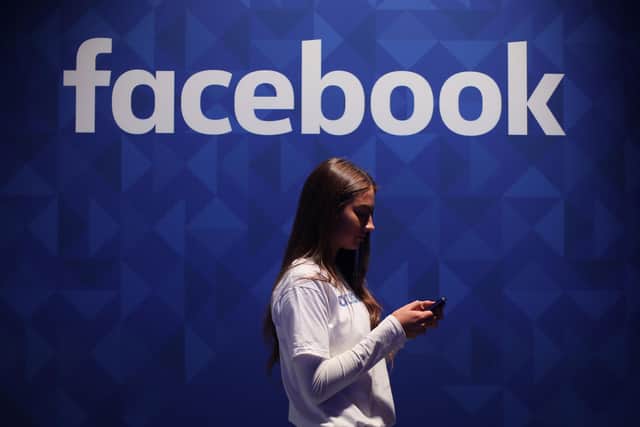 File photo dated 03/11/15 of a woman using her phone under a Facebook logo. Pic: PA