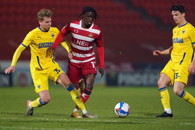 STEPPING UP: Doncaster Rovers' Taylor Richards battles with AFC Wimbledon's Daniel Csoka at the Keepmoat Stadium on Tuesday. Picture: Zac Goodwin/PA