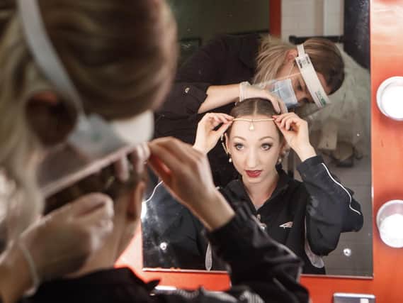 An assistant in PPE helps a ballerina get ready for a Northern Ballet performance at the Leeds Playhouse in November