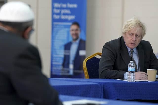Prime Minister Boris Johnson speaks to members of staff during  a visit to a coronavirus vaccination centre in Batley.