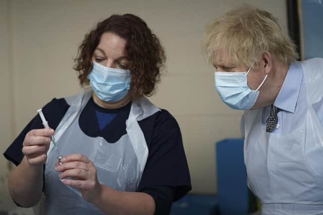 Prime Minister Boris Johnson is shown how to prepare the vaccine by advance nurse practitioner Sarah Sowden during a visit to a coronavirus vaccination centre in Batley.