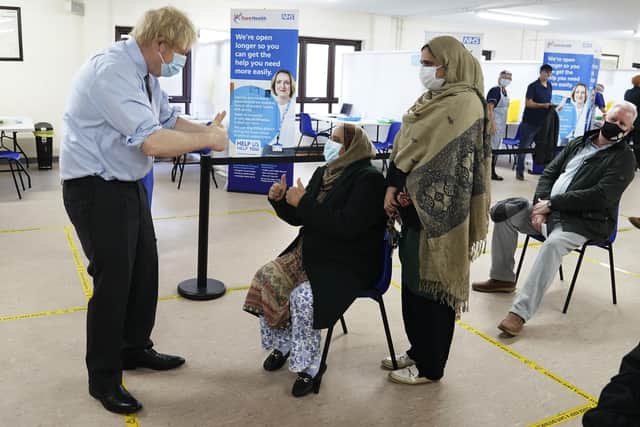 Prime Minister Boris Johnson gives a thumbs up to patients after they were given the vaccine during  a visit to a coronavirus vaccination centre in Batley.