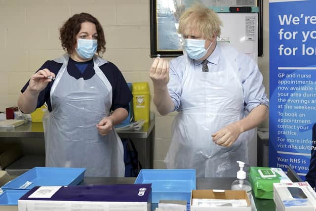 Prime Minister Boris Johnson is shown how to prepare the vaccine by advance nurse practitioner Sarah Sowden as he visited a COVID-19 vaccination centre in Batley