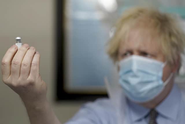 Prime Minister Boris Johnson holds a bottle of the Pfizer BioNTech vaccine during a visit to a coronavirus vaccination centre in Batley, West Yorkshire. Photo: PA
