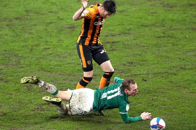 Tigers centre-half Reece Burke sends Lincoln's Anthony Scully tumbling.