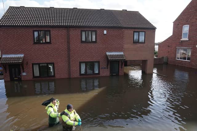 Rescue workers wade through water in the flooded village of East Cowick, Yorkshire, after Storm Jorge battered the UK