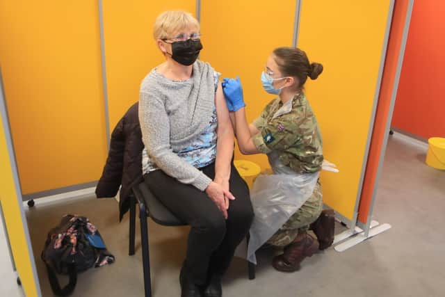 Diane Slack receives an injection of the coronavirus vaccine from a Ministry of Defence (MoD) employee at West Yorkshire's first large vaccination centre set up at Spectrum Community Health CIC, in Wakefield. Picture: Danny Lawson/PA Wire