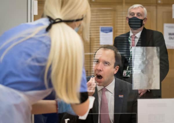 Health Secretary Matt Hancock takes a coronavirus test at a new Covid-19 testing facility in the Houses of Parliament in London watched by the Speaker of the House of Commons, Sir Lindsay Hoyle. Picture: Stefan Rousseau/PA Wire