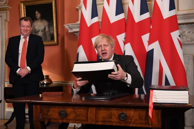UK chief trade negotiator, David Frost looks on as Prime MinisterPrime Minister Boris Johnson signs the EU-UK Trade and Cooperation Agreement at 10 Downing Street.