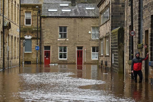 A man wades through floodwater in the streets of Hebden Bridge, northern England, on February 9, 2020, as Storm Ciara swept over the country. Photo by Oli SCARFF / AFP) (Photo by OLI SCARFF/AFP via Getty Images)