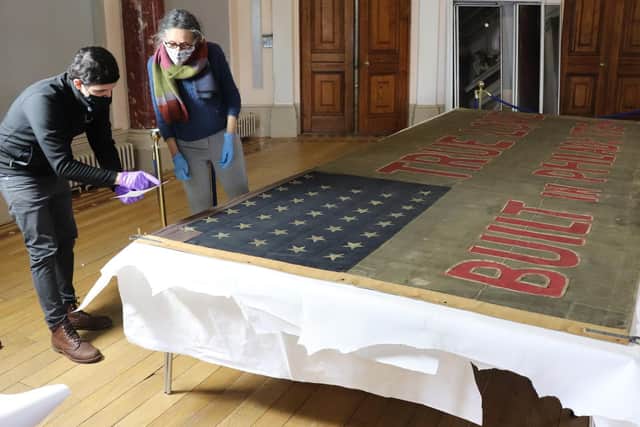 Conservators examine the flag in the city's Maritime Museum