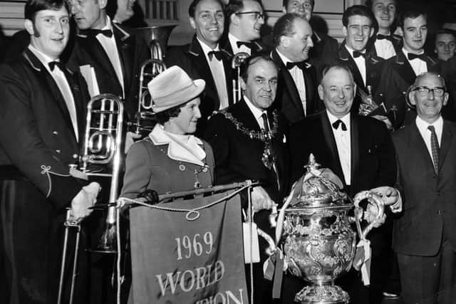 A civic welcome for Brighouse and Rastrick Band, on their return to Yorkshire after retaining the National and World Brass Band championship in 1969. With band members were the Mayor and Mayoress of Brighouse, Alderman and Mrs TH Gooder. Holding the trophy with the mayor is the Bandmaster JA Hickman and on the right is the band president, J Lakey.