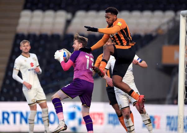 Got it: Hull City's Mallik Wilks challenges Milton Keynes Dons goalkeeper Andy Fisher. Picture: PA