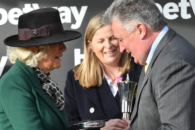 This Paul Nicholls receiving his 2020 Queen Mother Champion Chase trophy from the Duchess of Cornwall.