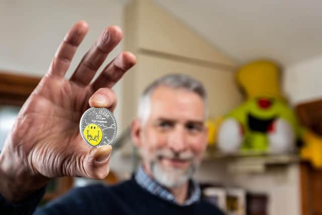 Adam Hargreaves, son of Mr Men and Little Miss creator Roger Hargreaves, holds The Royal Mint's new £5 Mr Happy coin, which launches today to celebrate 50 years of the characters.  Ciaran McCrickard/PA Wire