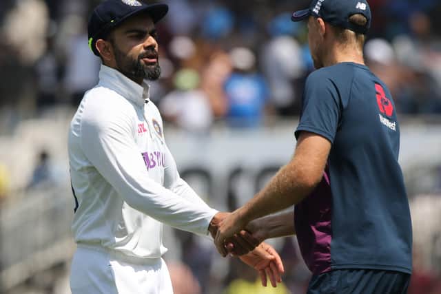 Well done: Virat Kohli is congratulated by Joe Root.