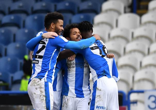 Well done: 
Huddersfield's Duane Holmes, centre, celebrates making it 3-1.
 
Picture: Jonathan Gawthorpe