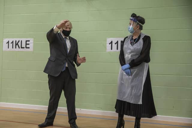 Prime Minister Boris Johnson (left) speaks to a member of staff in the gym, which is being used as a makeshift coronavirus testing centre for students, during a visit to Sedgehill School in Lewisham, south east London, to see preparations for students returning to school.