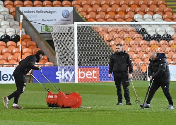 Blackpool groundstaff trying to remove the water of the playing surface. Picture: Picture Howard Roe/AHPIX