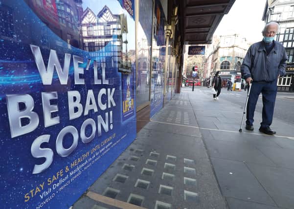 A man walks past a sign saying 'we'll be back soon' on the Prince Edward's Theatre in Soho, London, during the November national lockdown for England to combat the spread of Covid-19.