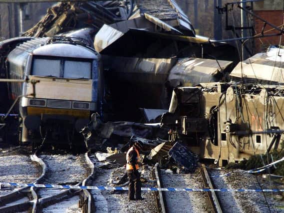 A policewoman walking across the track with the wreckage of the trains behind at the scene in Great Heck near Selby in 2001. PIC: PA