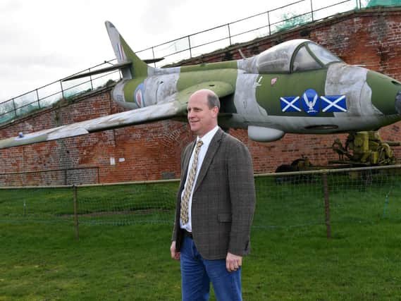 Auctioneer Andrew Baitson standing by the aircraft at Fort Paull near Hull Picture: Jonathan Gawthorpe