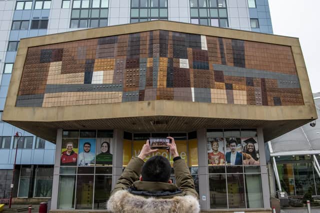 A student takes a picture of a mural designed and built by architect and artist Joseph Mayo in 1964, at the entrance of the Richmond Building at Bradford University. Photo credit: Tony Johnson/JPIMediaResell