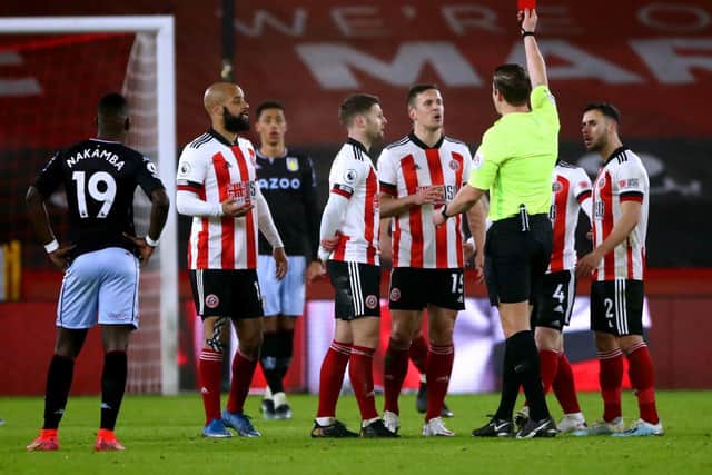 Sheffield United's Phil Jagielka (centre right) sees his yellow card upgraded to a red card after referee Robert Jones consults the VAR. Picture: PA
