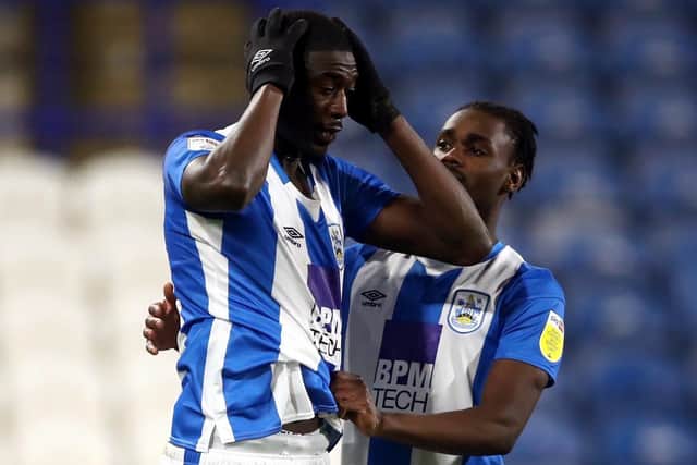 Huddersfield Town's Yaya Sanogo consoled by Aaron Rowe after missing a penalty.