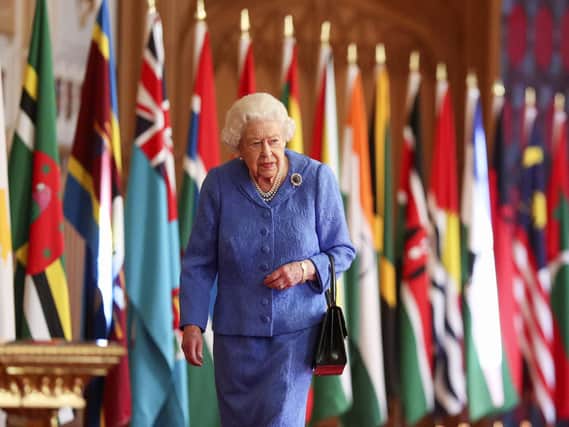 Queen Elizabeth II walks past Commonwealth flags in St George's Hall at Windsor Castle , to mark Commonwealth Day.