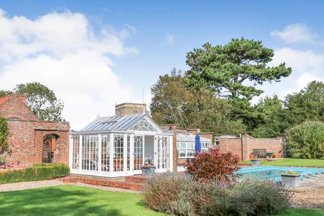 The property has large grounds with an outdoor swimming pool