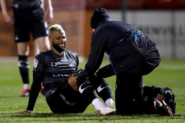 Doncaster Rovers' John Bostock receives medical treatment after going down injured.