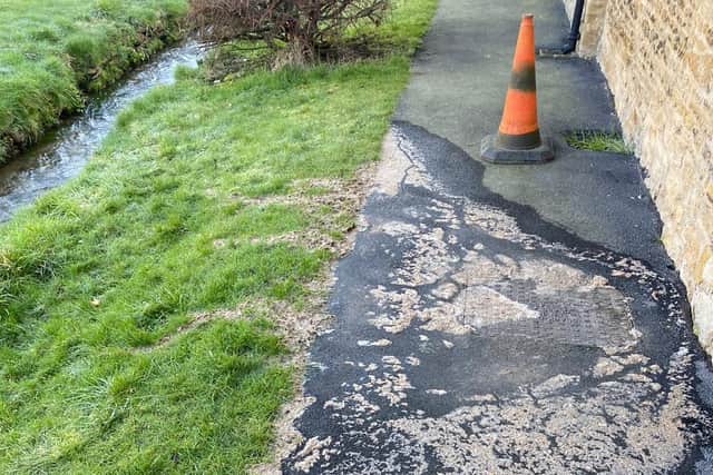 Sewage leaking onto a pavement in the village