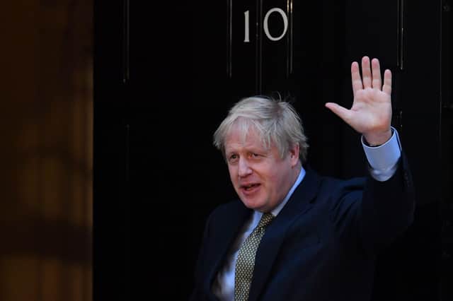 Boris Johnson waves as he returns to 10 Downing Street in central London on December 13, 2019, after delivering a speech following his Conservative party's general election victory.(Photo by Ben STANSALL / AFP)